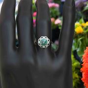 Garden of Glow: Floral Style Halo Ring with Dazzling Portuguese Cut Cyan Blue Moissanite in Silver